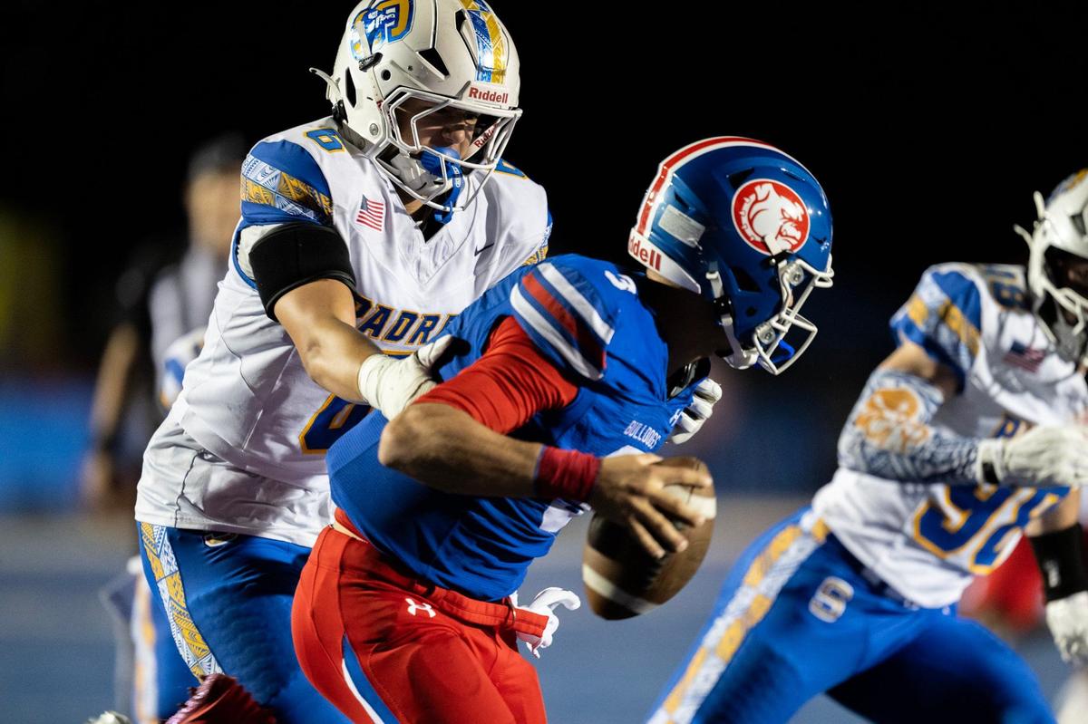 Serra Padres lineman Tommy Miller (6) grabs Folsom Bulldog quarterback Ryder Lyons (3) on Friday at Folsom High School.