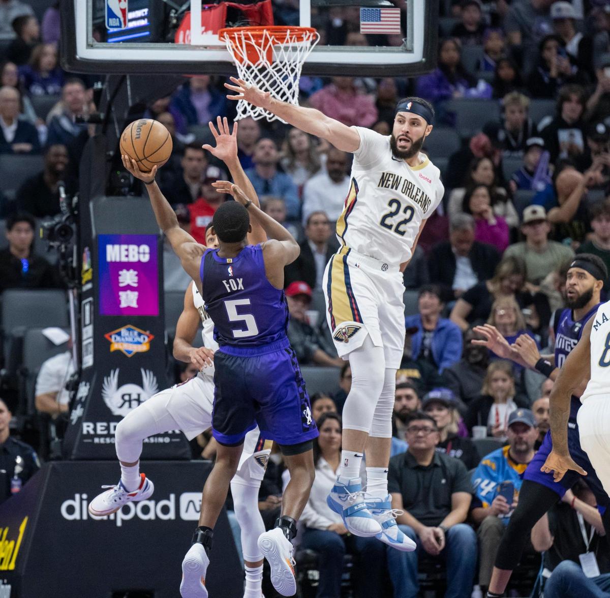 Sacramento Kings guard De’Aaron Fox (5) shoots over New Orleans Pelicans forward Larry Nance Jr. (22) and guard CJ McCollum (3) in the first half of the NBA basketball game on Sunday, Jan. 7, 2024, at Golden 1 Center.