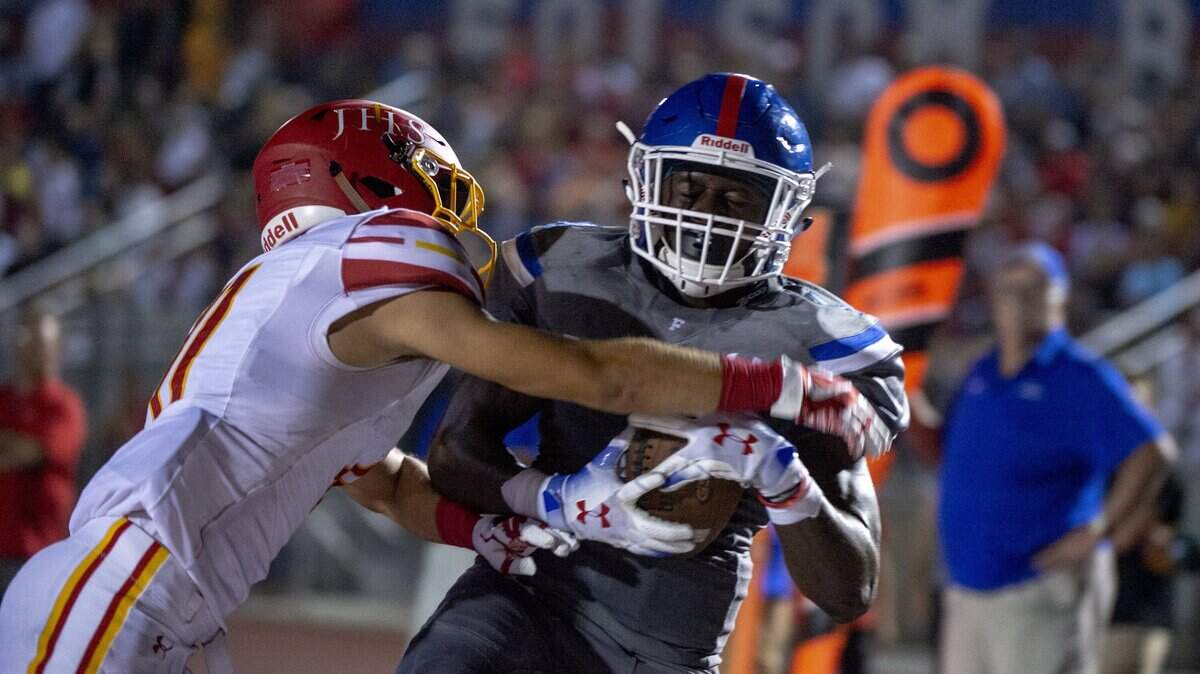 Folsom Bulldogs Daniyel Ngata (4) catches a 7-yard touchdown pass while defended by Jesuit Marauders Spencer Vigil (11) in the second quarter as the Folsom Bulldogs hosted the Jesuit Marauders on Friday, August 24, 2018.