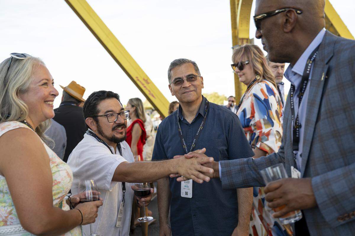 Sacramento City Councilmember Eric Guerra, center, shakes hands with Sacramento County Sheriff Jim Cooper, right, as former U.S. Secretary of Health and Human Services Xavier Becerra looks on during the Tower Bridge Dinner on Sunday, Sept. 7, 2025.