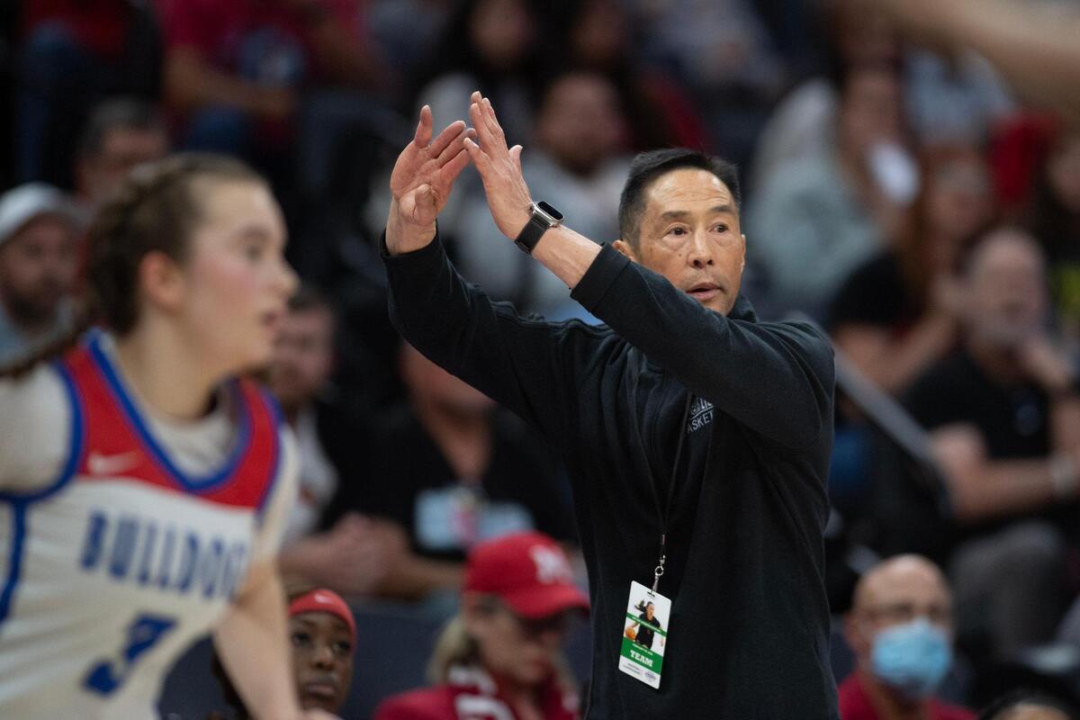 The McClatchy Lions’ head coach Jeff Ota signals for a timeout late in the fourth quarter in the second half of the Sac-Joaquin Section Division I girls basketball championship game against the Folsom Bulldogs on Friday.