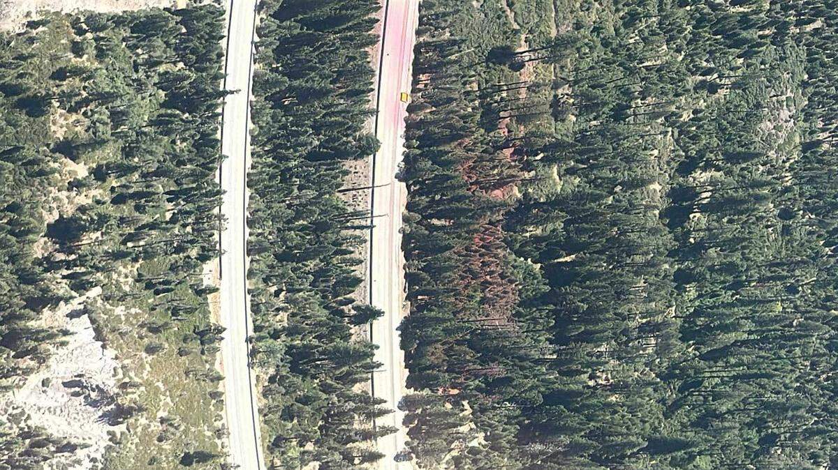 Lanes of Interstate 80 are seen empty near Emigrant Gap as firefighters worked to extinguish a fire sparked by a Tesla Semi big-rig vehicle that crashed Monday, Aug. 19, 2024. The Tesla Semi ended up several yards off the roadway, marked by faint lines of fire retardant that was dropped by plane.