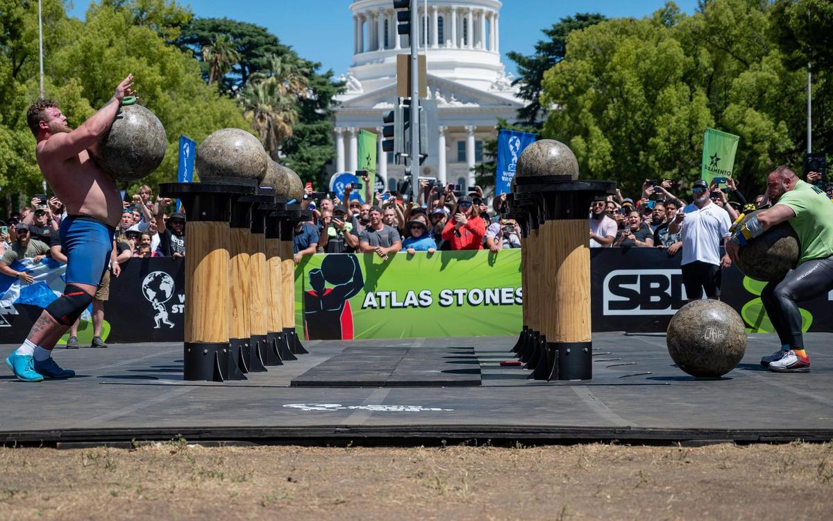 Tom Stoltman, left, of Great Britain, and Oleksii Novikov, of Ukraine, race to finish lifting the Atlas stones during the final event in the World’s Strongest Man competition at Capitol Mall in downtown Sacramento on Sunday, May 29, 2022. The five stones, weighing from 309 to 441 pounds, must be lifted and placed onto a high platform. Stoltman won the event and the overall competition.
