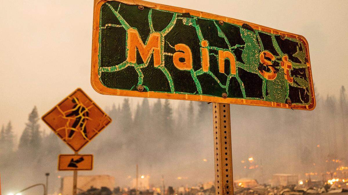 A street sign stands in central Greenville as the Dixie Fire tears through Plumas County, California, on Wednesday. The fire leveled multiple historic buildings and dozens of homes in the community. (Noah Berger/AP)