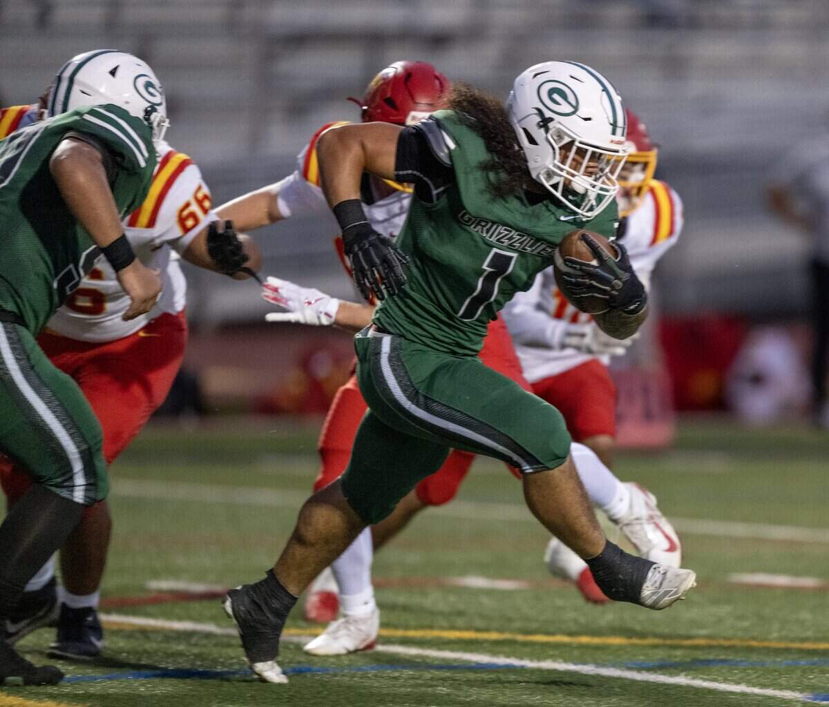 The Granite Bay Grizzlies' Isaiah Ene (1) runs through the Jesuit Marauders defense in the first half on Friday, Sept. 19, 2025, in Granite Bay.