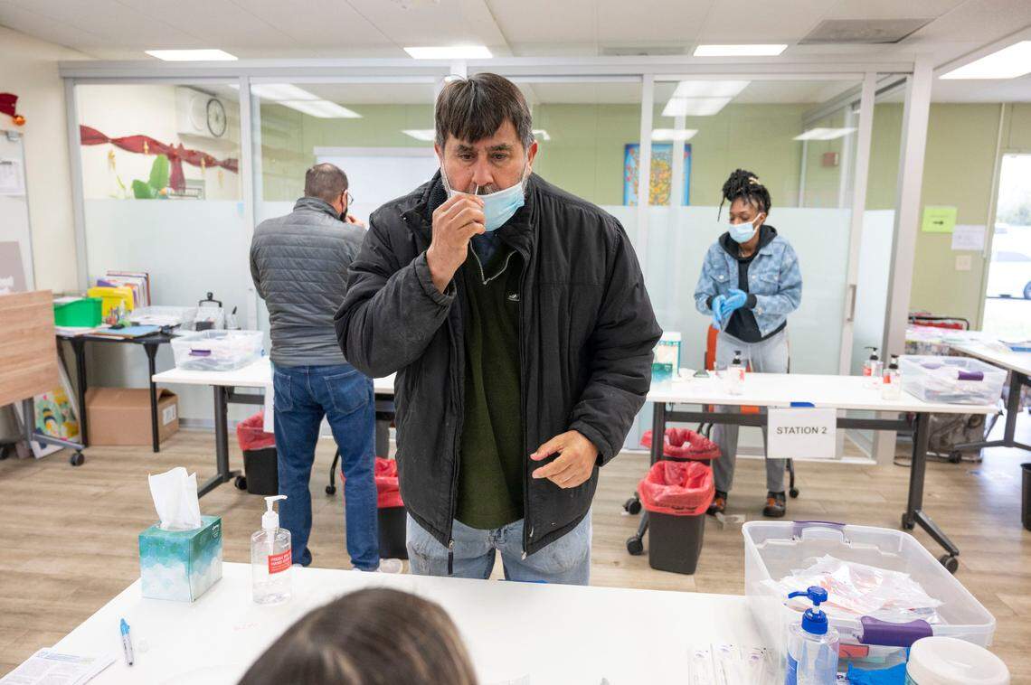 Alberto Davalos, of Sacramento, inserts a swab for a COVID-19 test Monday at La Familia Counseling Center in south Sacramento. Some people waited more than two hours for a test but the center, which had planned to close for a lunch break, stayed open to accommodate the long lines.