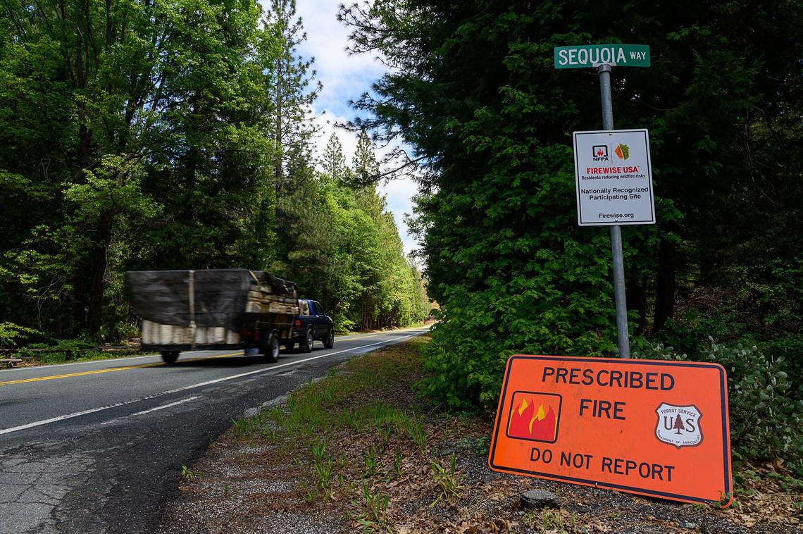 A vehicle drives by down Foresthill Road on Friday, May 24, 2019, passing a sign that warns the U.S. Forest Service has performed a prescribed burn in the area to help fire suppression in the Tahoe National Forest.