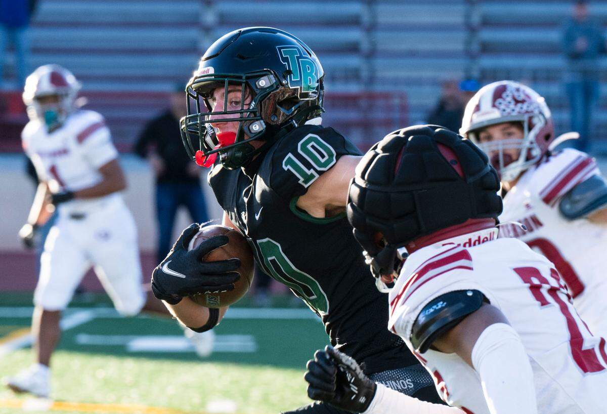 Twelve Bridges Raging Rhinos’ Dylan Amos (10) races past Patterson Tigers’ Romeo Manu (26), turning catch in the flat into a 25-yard touchdown reception, in the second quarter of the Sac-Joaquin Section Division IV championship game at Hughes Stadium in Sacramento on Friday, Nov. 29, 2024.