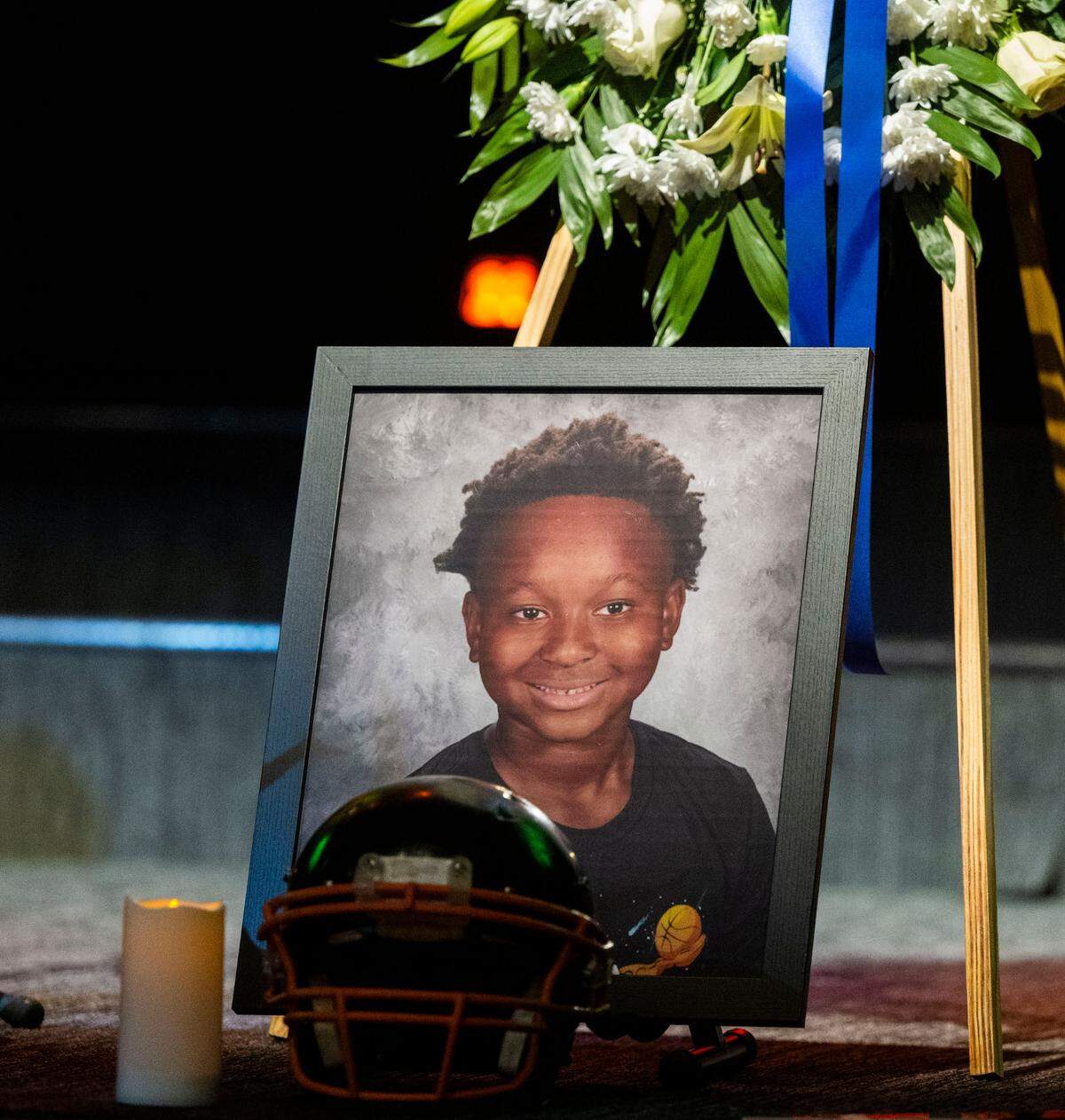 A photo of Keith “KJ” Frierson is displayed with his Jr. Mustangs football helmet at his funeral service at Liberty Towers Church in Foothill Farms on Saturday.