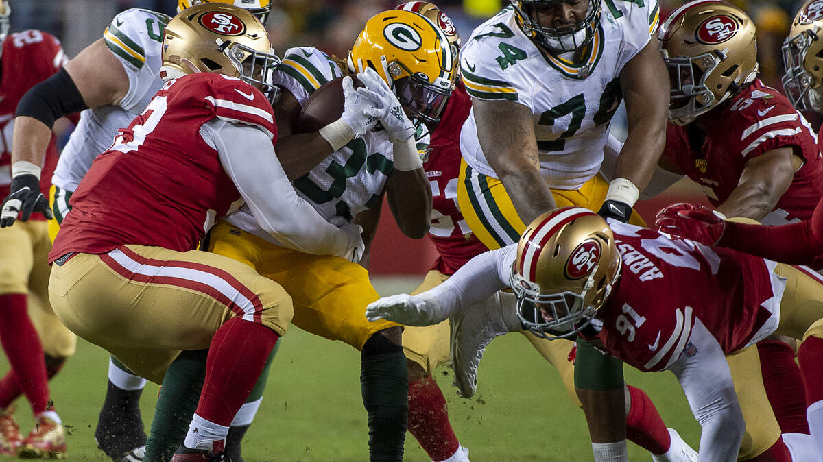 Green Bay Packers’ Aaron Jones (33) is tackled by San Francisco 49ers’ D.J. Jones (93), San Francisco 49ers’ Azeez Al-Shaair (51) and San Francisco 49ers’ Arik Armstead (91) during a game at Levi’s Stadium on Sunday, November 24, 2019 in Santa Clara.