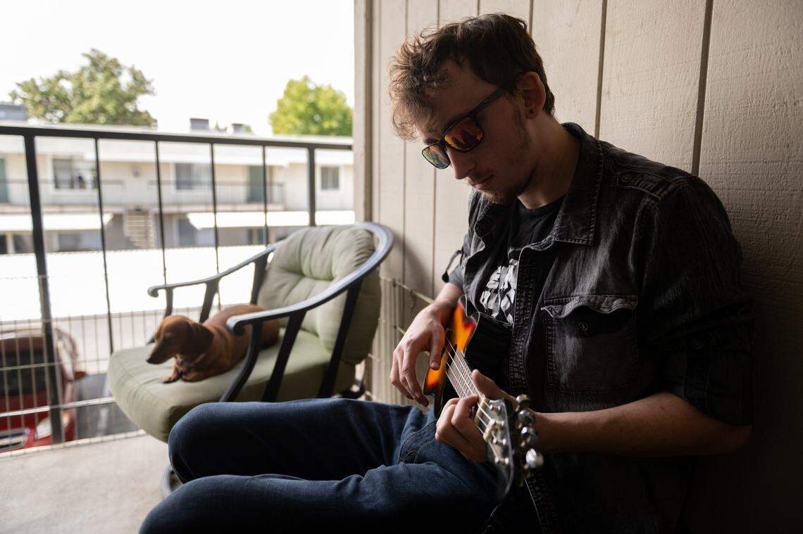 Oliver Easton plays a ukulele, given to him by his mother Sara Easton when he was a child, in September on his patio in Yuba City. He stayed with his mother’s parents in California when his father Aaron Easton moved to Oklahoma.