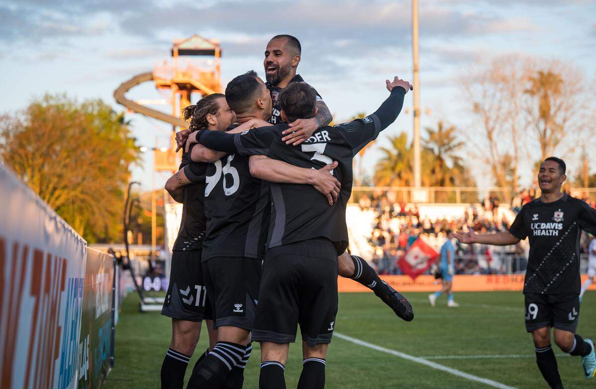El mediocampista de Sacramento Republic FC Rodrigo “RoRo” López (8), arriba, salta sobre sus compañeros celebrando el primer gol del equipo contra Louisville City FC durante la primera mitad de un partido de la USL en Heart Health Park en 2023.