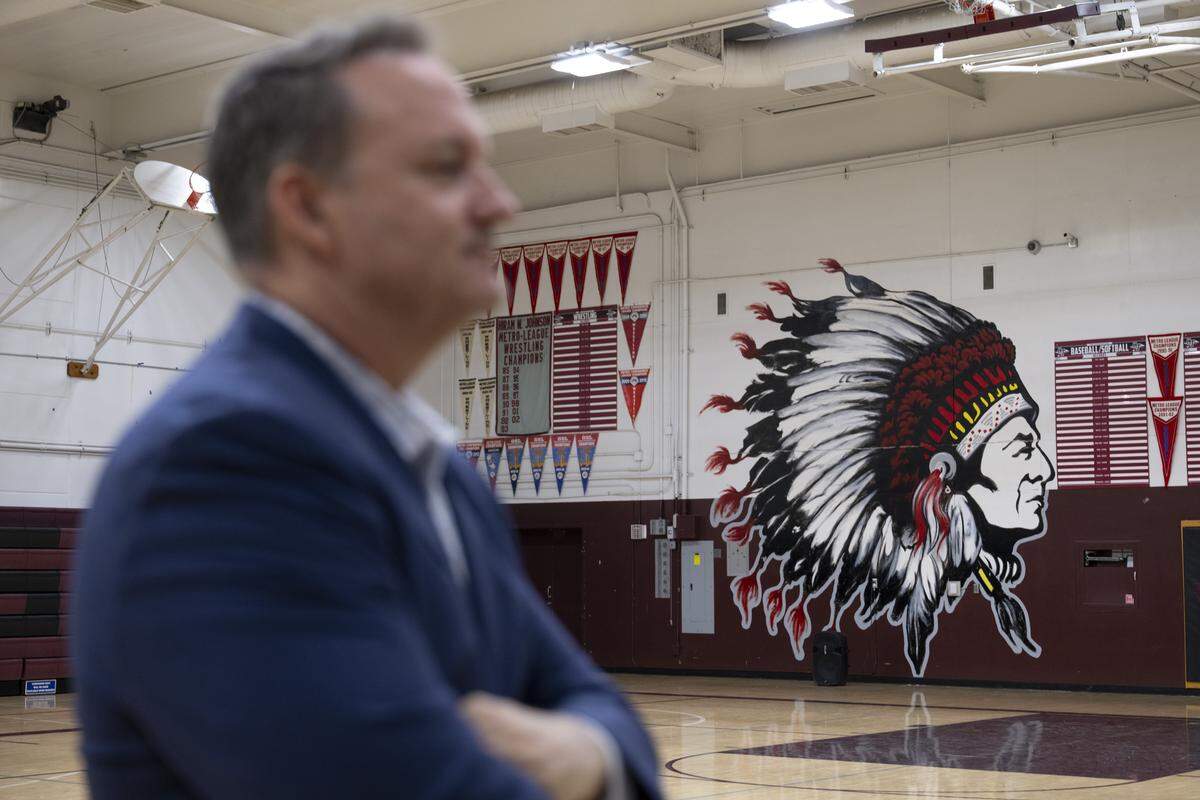 Hiram Johnson High School Principal Garrett Kirkland stands near a controversial mural in the school’s gym in Sacramento on May 5. 