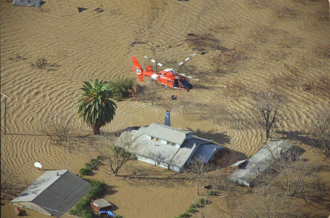 The crew of a Coast Guard helicopter rescues a man stranded on the roof of his Olivehurst home on Jan. 3, 1997, after a levee along the Feather River ruptured the nigh before sending acres of water into the community.