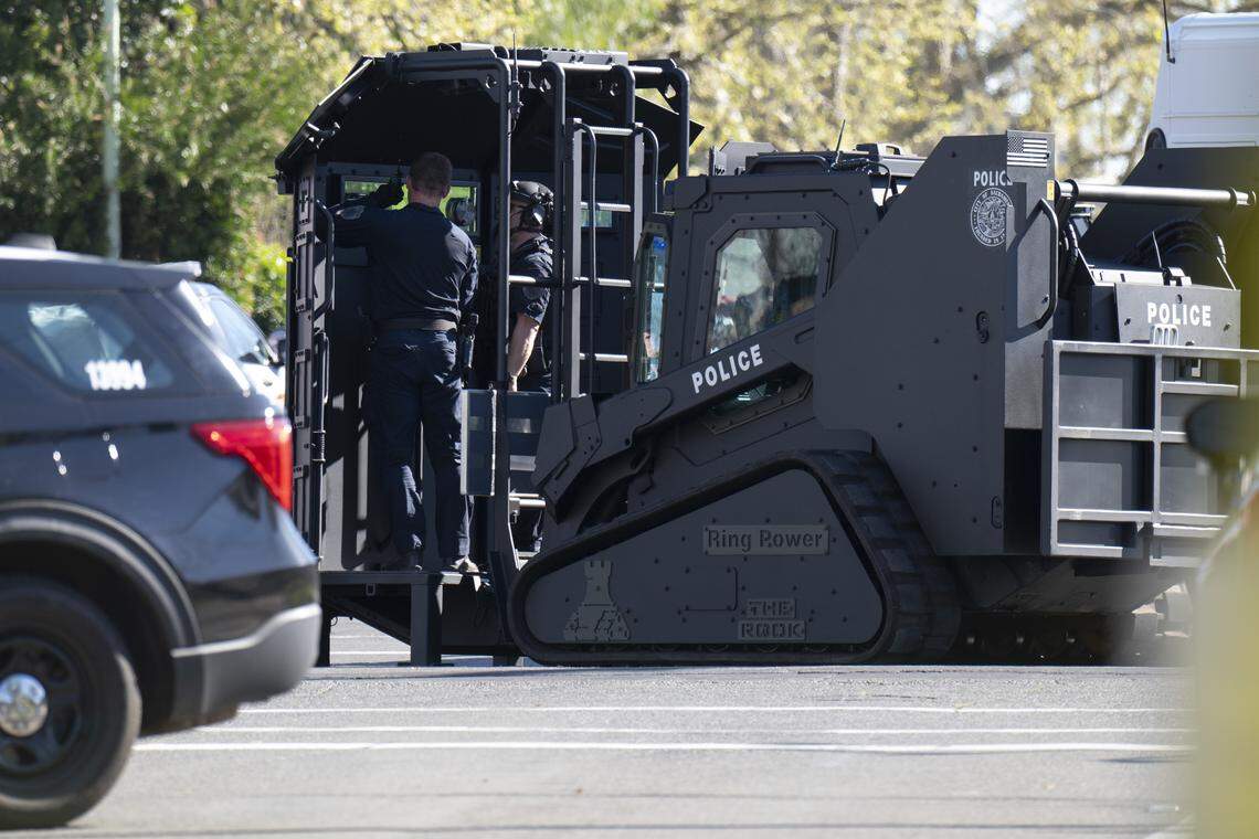 Sacramento Police officers use an armored vehicle while responding to a standoff incident at the Oak Park Market in south Oak Park on Thursday.
