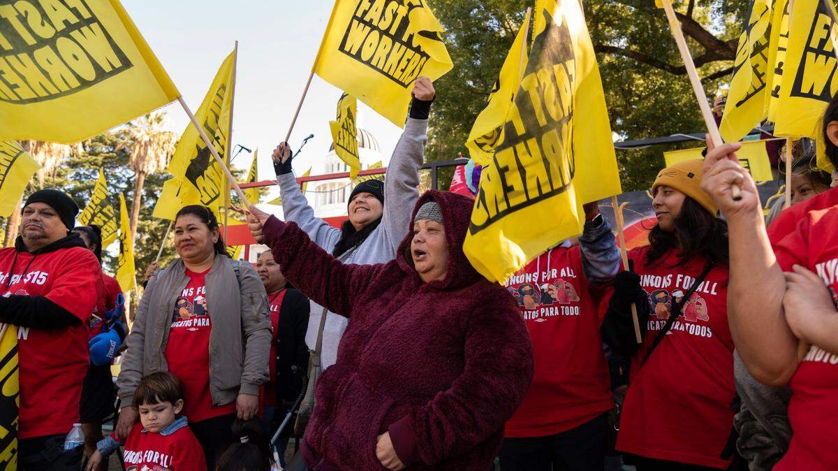 Sandra Jáuregui, centro, trabajadora de restaurantes de comida rápida durante 14 años, y otros trabajadores de la industria se manifiestan en el Capitolio estatal en Sacramento el martes 15 de noviembre de 2022, exigiendo que las empresas de comida rápida como McDonald's, In-N-Out Burger y Chipotle dejen de tratar de derogar el Proyecto de Ley de la Asamblea 257, que crea un concejo laboral dirigido por el gobierno para la industria.