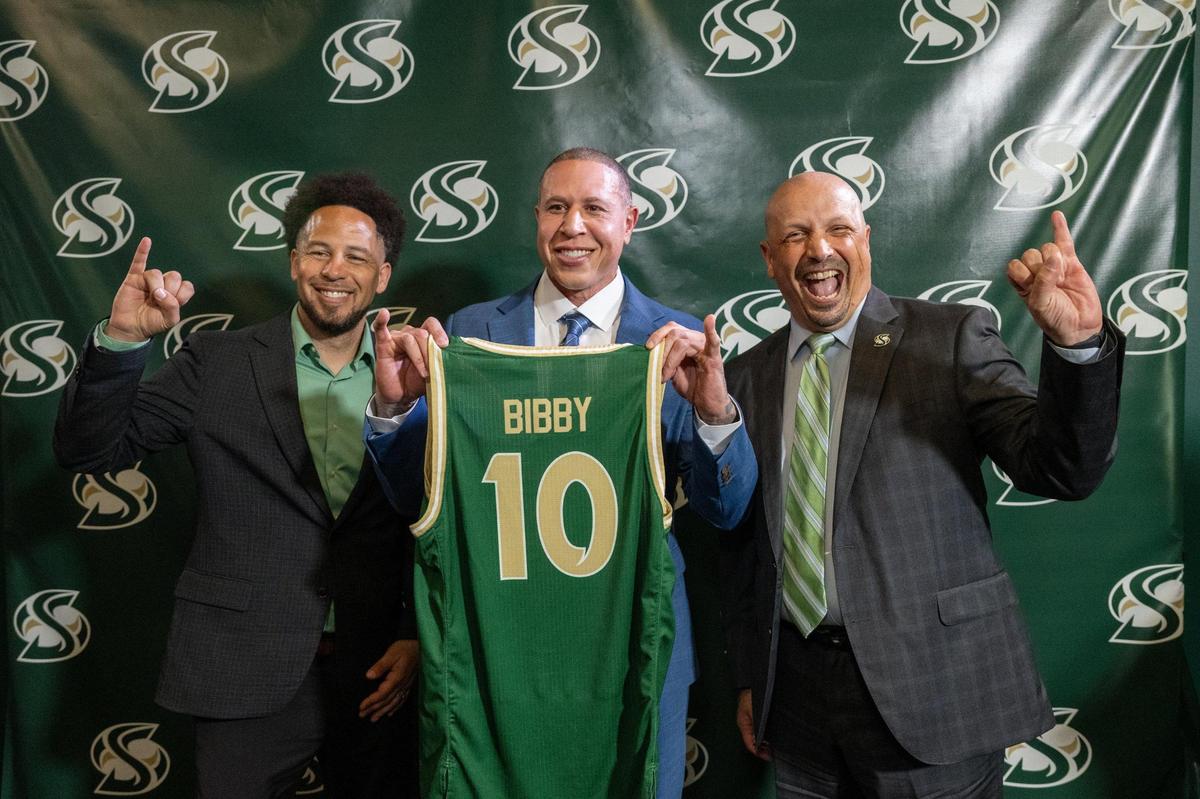 Mike Bibby, the former Sacramento Kings star, poses with university president Luke Wood, left, and athletic director Mark Orr during a campus press conference introducing him as Sacramento State’s head basketball coach on April 1. 