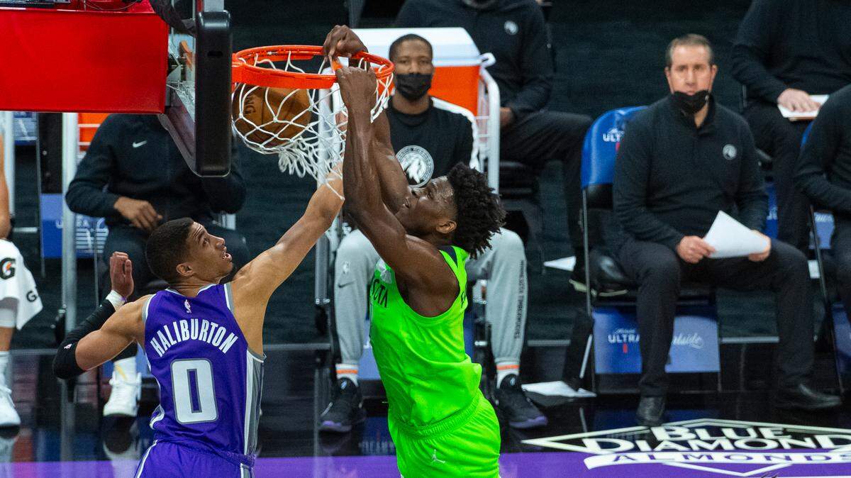 Minnesota Timberwolves forward Anthony Edwards (1) dunks as Sacramento Kings guard Tyrese Haliburton (0) defends during the first quarter of an NBA basketball game in Sacramento, Calif., Tuesday, April 20, 2021. (AP Photo/Randall Benton)