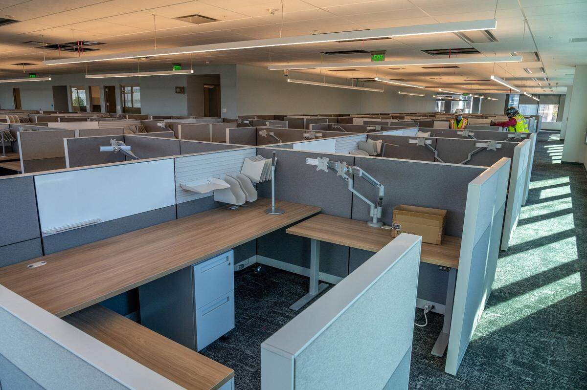 Cubicles in the new building have a sitting and standing desks.