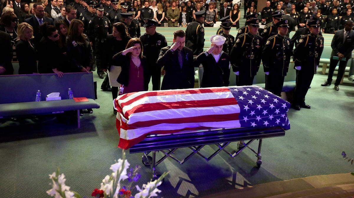 The children of slain Whittier police Officer Keith Wayne Boyer, daughter Ashley Sheleretis, and sons Joshua and Joseph Boyer, salute his coffin during funeral service at Calvary Chapel Downey. Boyer’s death is a devastating example of what happens when our supervision system fails.