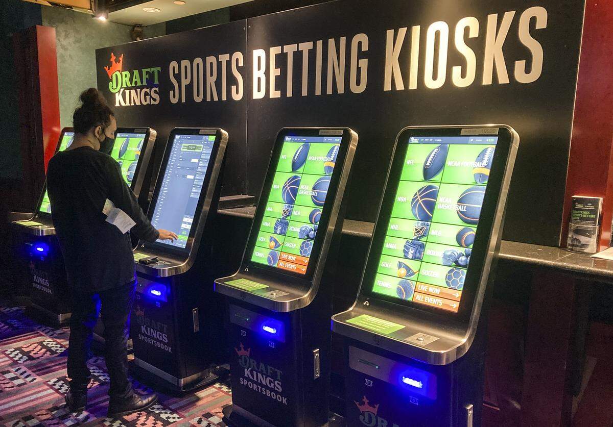 A man places a bet at one of the new DraftKings sports wagering kiosks at Foxwoods Resort Casino in Mashantucket, Conn., in September.