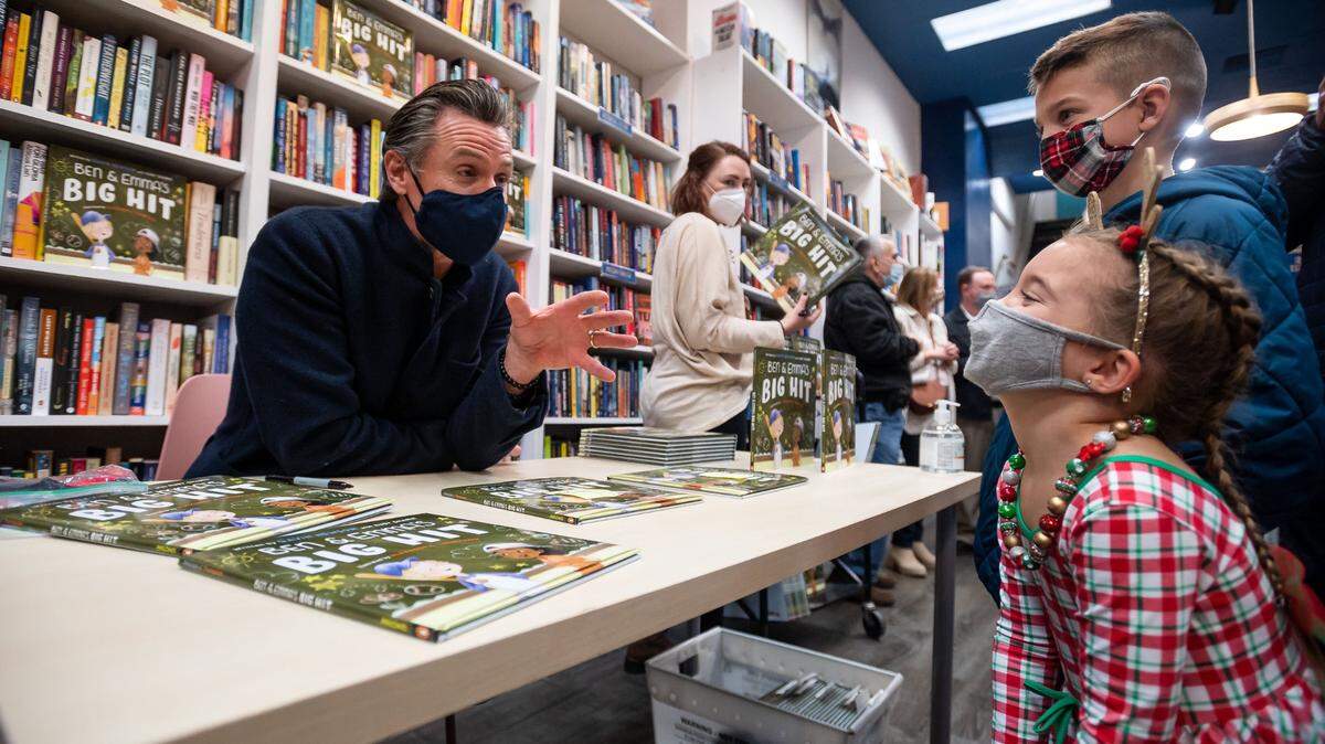 Ellie Gooch, 5, laughs while talking with Gov. Gavin Newsom after he signs a copy of his children’s book, “Ben and Emmas Big Hit,” for her at Capital Books on Dec. 11 in downtown Sacramento. When he asked her what she’s most looking forward to, she said “Christmas and Jesus’ birthday,” to which he replied, “thank you, lots of people forget that!” Ellie traveled with her brother, Carter Gooch, 8, and father, Travis Gooch, from Manteca for the book signing event. Newsom said he wrote the book, based on his struggles with dyslexia, to help inspire kids to see their learning differences as gifts.