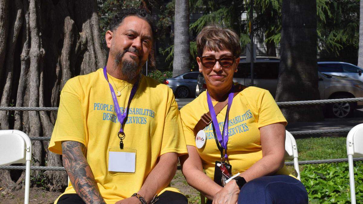 Disability care workers Ricardo Zegri and Niurka Sureda-Jackson sit outside the California state Capitol on April 10 in Sacramento. Zegri says Taco Bell would pay him more than the $19 an hour he makes as a disability care worker in a supervisory position.