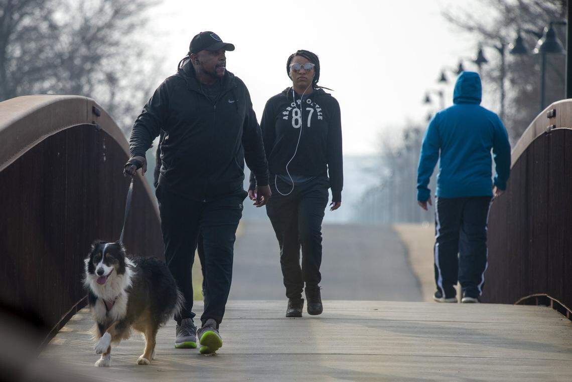 Vernon Venerable, left, walks with his daughter Vanessa and their dog Daisy at the North Natomas Regional Park in 2021.