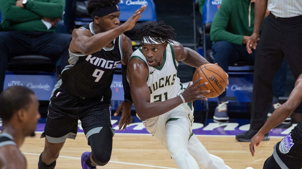 Sacramento Kings guard Terrence Davis (9) defends against Milwaukee Bucks guard Jrue Holiday (21) during the second half of an NBA basketball game in Sacramento, Calif., Saturday, April 3, 2021. The Bucks won 129-128. (AP Photo/Randall Benton)