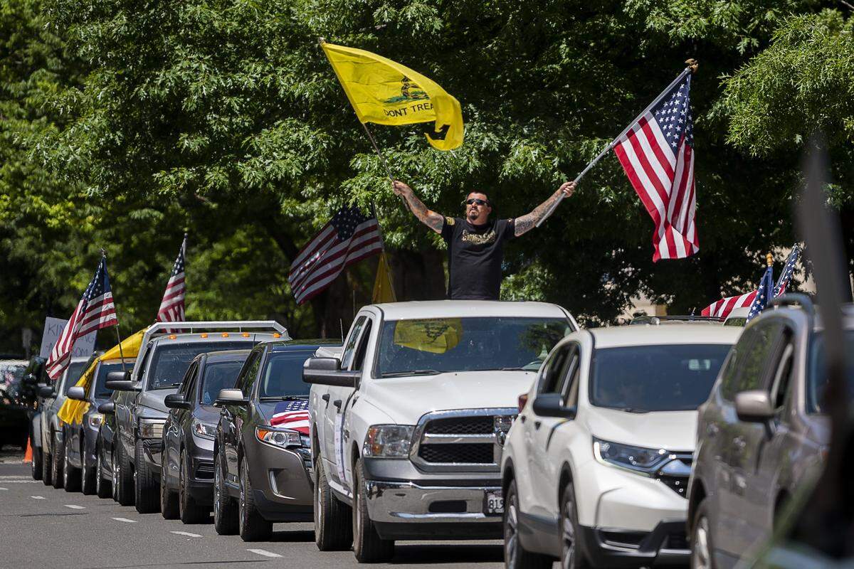 Protesters drive down N Street as they demonstrate at the Capitol in Sacramento on Friday, May 1, 2020, against Gov. Gavin Newsom’s stay-at-home order to slow the spread of the coronavirus.