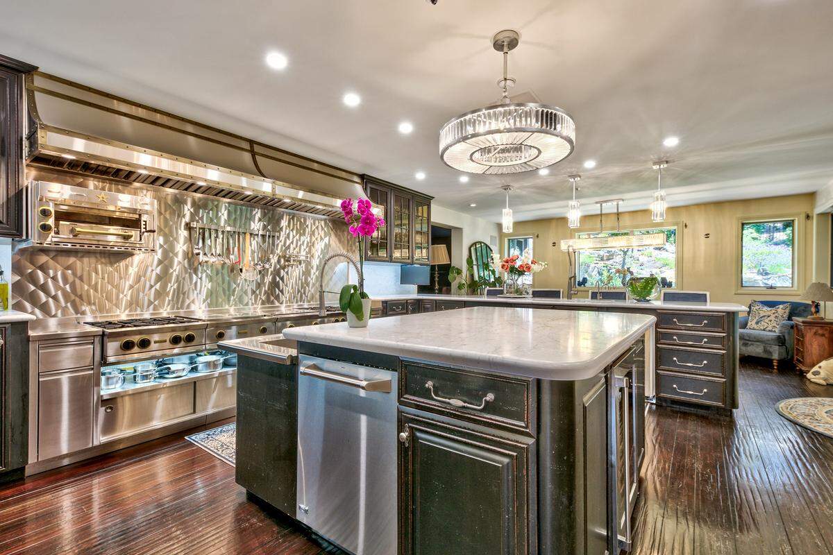 Vaulted ceilings and expansive windows frame breathtaking lake and mountain vistas, while a chef’s kitchen stands ready for both cozy family meals and grand entertaining.