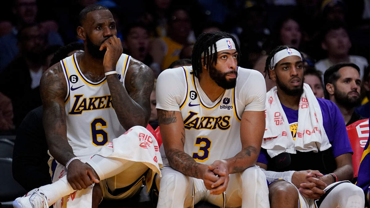 From left to right, Los Angeles Lakers forward LeBron James, forward Anthony Davis and forward Troy Brown Jr. sit on the bench in the closing minutes of a loss to the Cleveland Cavaliers in an NBA basketball game Sunday, Nov. 6, 2022, in Los Angeles. (AP Photo/Marcio Jose Sanchez)