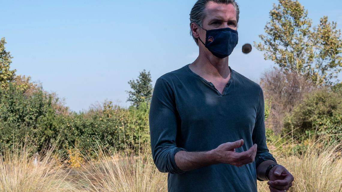 California State Governor Gavin Newsom tosses a walnut as he tours Sierra Orchards walnut farm in Winters in Solano County on Wednesday, Oct. 7, 2020.