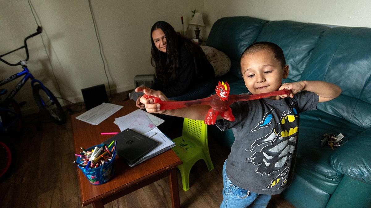 Michael Gamino Correa, 5, plays with a toy after completing his school Zoom class with his mom Rosario Correa, 34, at home on Thursday, March 18, 2021, in Sacramento. The single Latina mother changed her work schedule to a night shift to help supervise her three children’s schooling during the day.