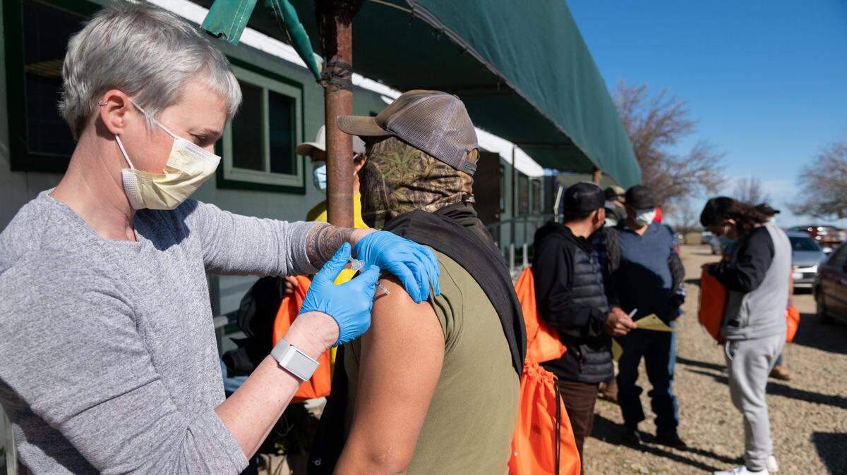 Yolo County EMS Administrator Kristin Weivoda gives the COVID-19 vaccine to a farmworker on Wednesday, Feb. 17, 2021 at Durst Organic Growers near Esparto.
