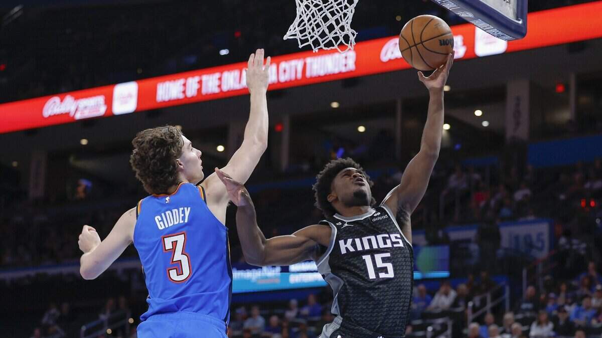 Sacramento Kings guard Davion Mitchell (15) goes up for a basket Tuesday in front of Oklahoma City Thunder guard Josh Giddey (3) during the second quarter at Paycom Center.