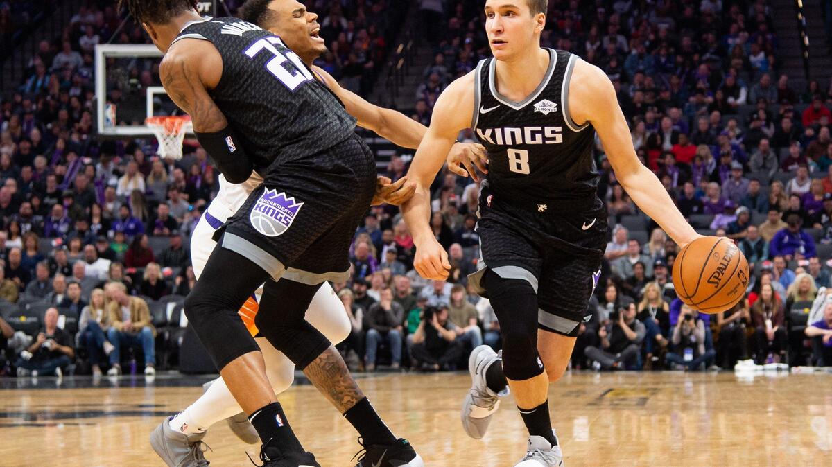 Sacramento Kings guard Bogdan Bogdanovic (8), right, dribbles past Phoenix Suns guard Elie Okobo (2), with help from a Richaun Holmes pick, on his way to a three-point play during the fourth period of their NBA game Saturday, Dec. 28, 2019, at Golden 1 Center in Sacramento.