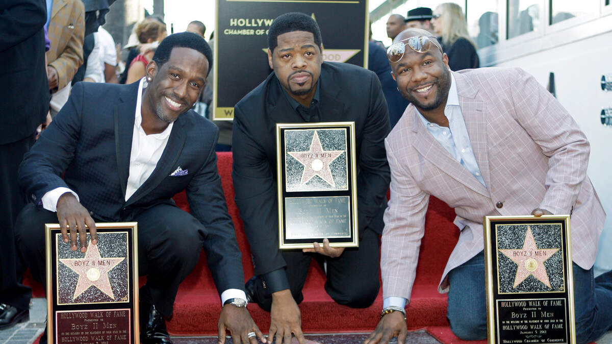 The R&B group Boyz II Men, from left, Shawn Stockman, Nathan Morris and Wanya Morris, touch their new star on the Hollywood Walk of Fame at dedication ceremonies in Los Angeles Thursday, Jan. 5, 2012. The group will perform in Stockton, CA on Sept. 25, 2021. (AP Photo/Reed Saxon)
