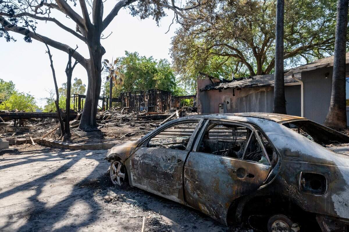 A burned car sits among the remains of Compassion Ranch, a group home for aged-out foster youth, on Tuesday, days after the Newcastle facility burned.