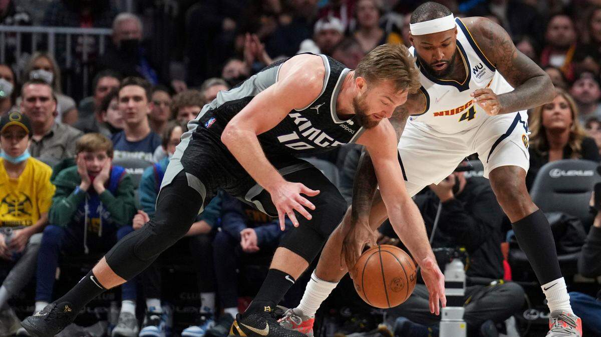 Sacramento Kings’ Domantas Sabonis (10) and Denver Nuggets center DeMarcus Cousins reach for the ball during the third quarter of an NBA basketball game Saturday, Feb. 26, 2022, in Denver. (AP Photo/Jack Dempsey)