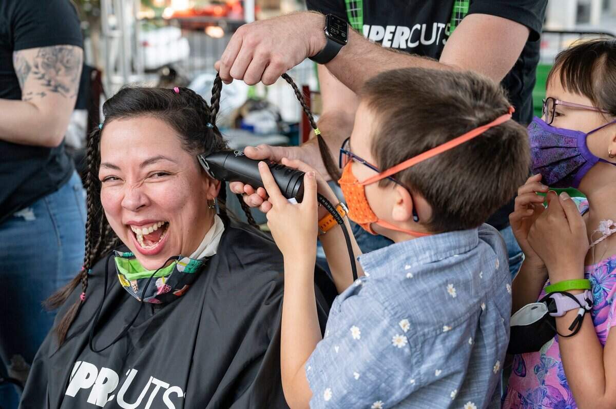 Orlana Van Zandt of Sacramento laughs as son Oliver, 8, shaves her hair while daughter Gwendolyn, 9, watches during the St. Baldricks event.