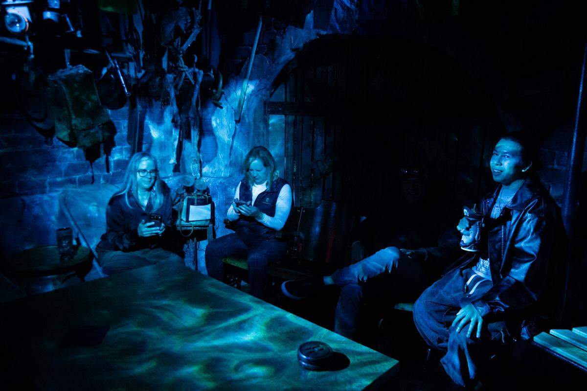 Megan Van Voorhis, left, Traci Rockefeller Cusack and Jacob Ball enjoy the lightshow at Hawthorne’s Hideout on Thursday in Old Sacramento.