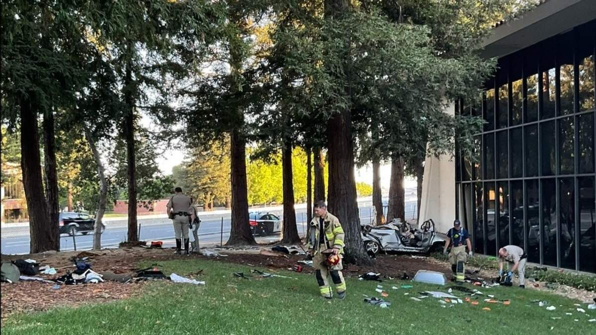 California Highway Patrol and Sacramento Metropolitan Fire District personnel look through debris after a BMW SUV veered off of Highway 50 and crashed into trees and a vacant office building in Rancho Cordova, California, on Monday, September 5, 2022.