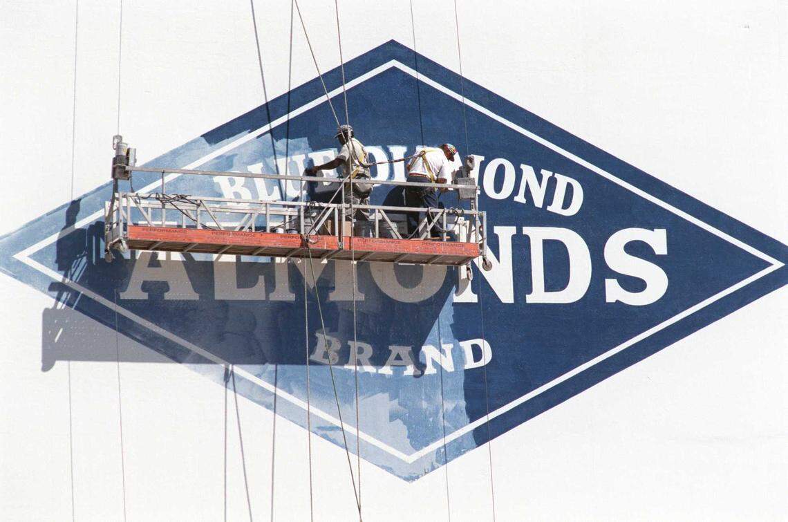 Robert Canon and Dan Feusi of Dan-D-Signs paint the Blue Diamond logo on a building at the almond cooperative’s Sacramento plant in 1997.