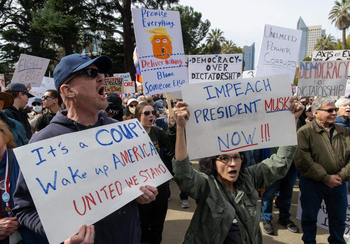 “Impeach President Musk now!” reads a sign held by a demonstrator participating in a President’s Day protest on Feb. 17, organized by the grassroots 50501 Movement, against President Donald Trump and his administration.