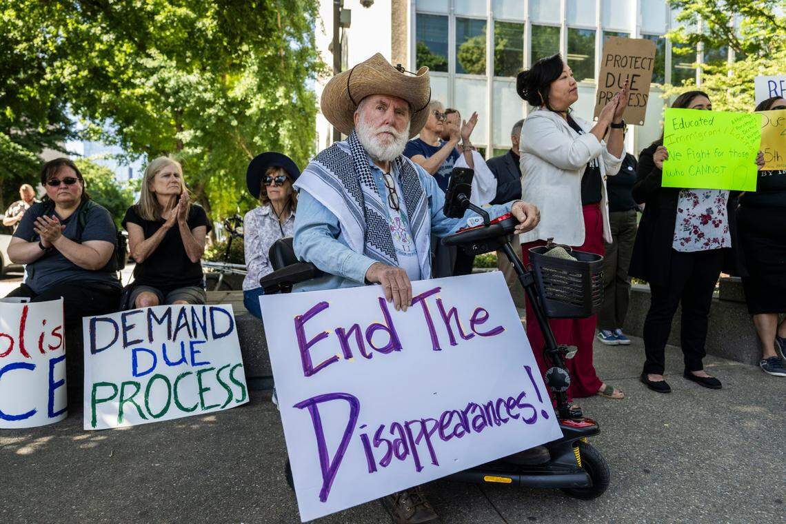 Elk Grove resident Seán Puskamp, holding a sign saying “end the disappearances,” joins a rally in May against ICE arrests and deportations at the U.S. Citizenship and Immigration Services building in downtown Sacramento.