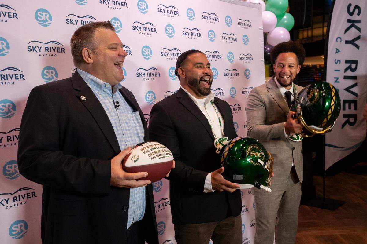 Wilton Rancheria Chairman Jesus Tarango holds a Sacramento State football helmet with a tribal design as he stands between university president Luke Wood, right, and associate athletic director Andy Fiske during a news conference at Sky River Casino in Elk Grove on Friday. The tribe and the school announced a multi-year partnership at the event.