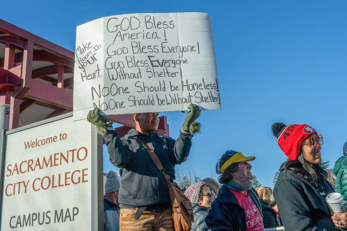 Treci Gorin holds a sign that says “God bless everyone” and “no one should be without shelter” before the March for the Dream honoring Martin Luther King Jr. on Monday at Sacramento City College.