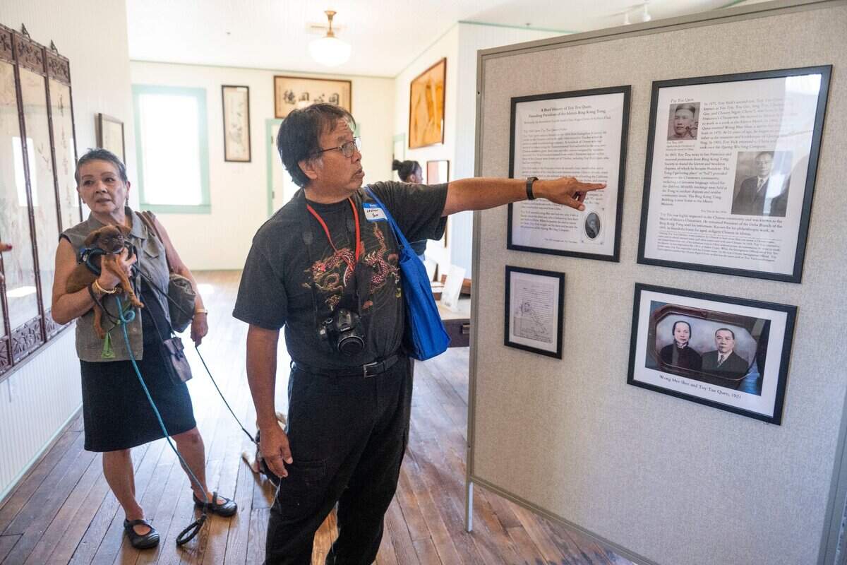 Karen Chan, left, and her cousin Lester Yee, both descendants of the Toy family look at a display of the patriarchs of their family on Thursday in Isleton.