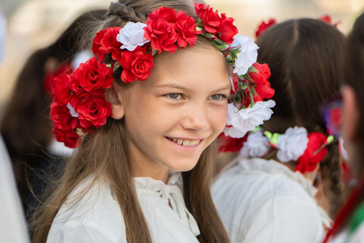 Philomena Barbarich, 11, talks with her fellow members of her Italian dance troupe while waiting for the Frecce Tricolori jet team to arrive at Mather Airport near Rancho Cordova on Tuesday. Barbarich was one of several young performers to greet the Italian pilots upon their arrival.